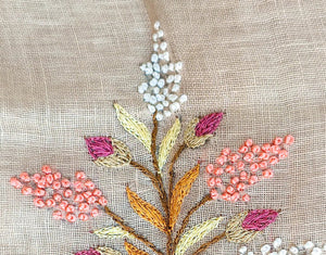 Embroidered floral design on fabric with 'liveinwonderland' branding.