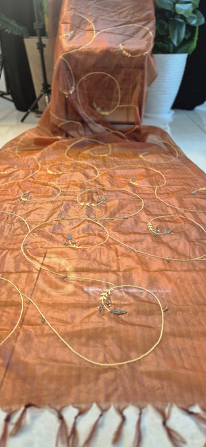 Brown fabric with gold embroidery on a wooden surface