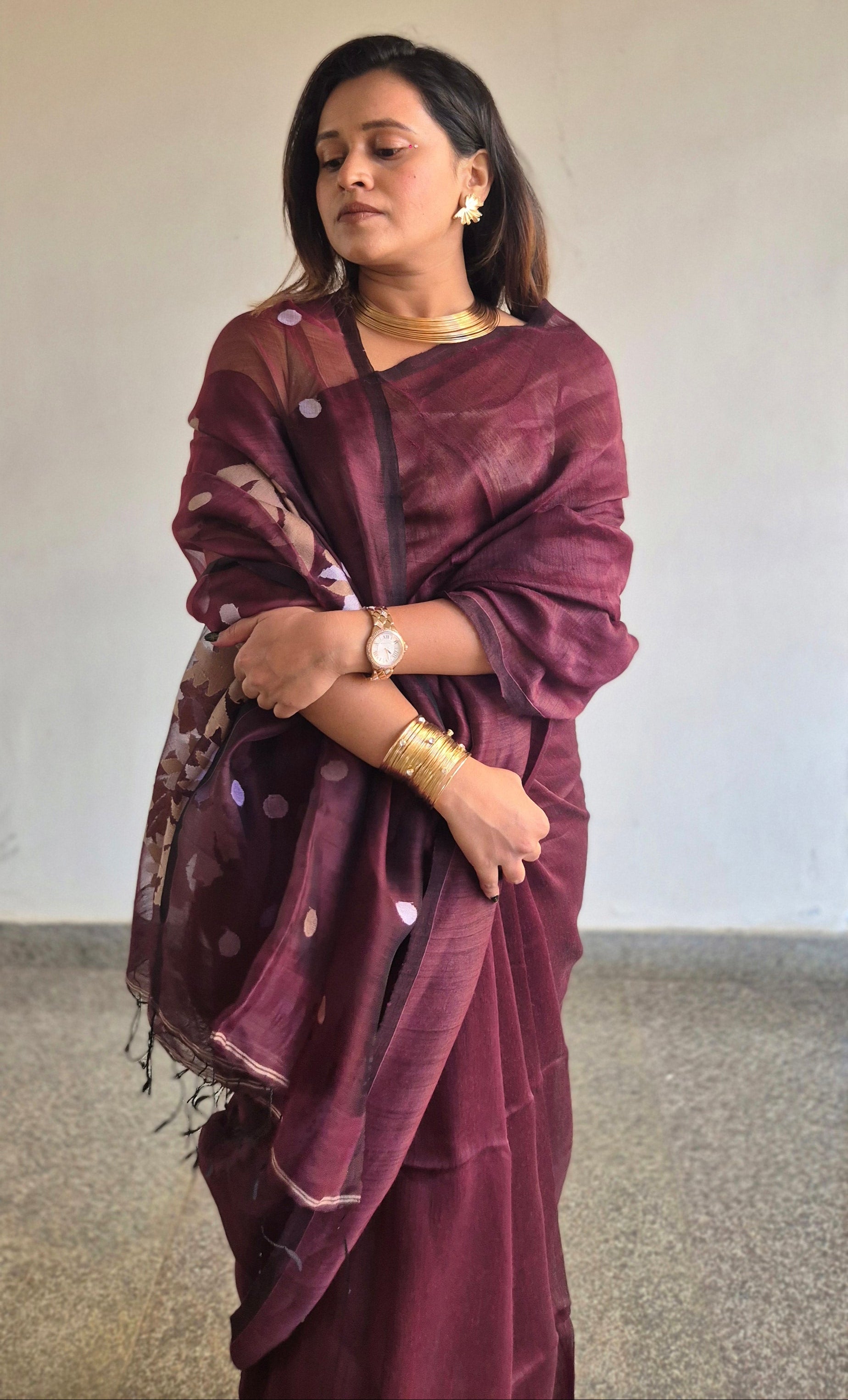 Woman wearing a maroon saree with a white background