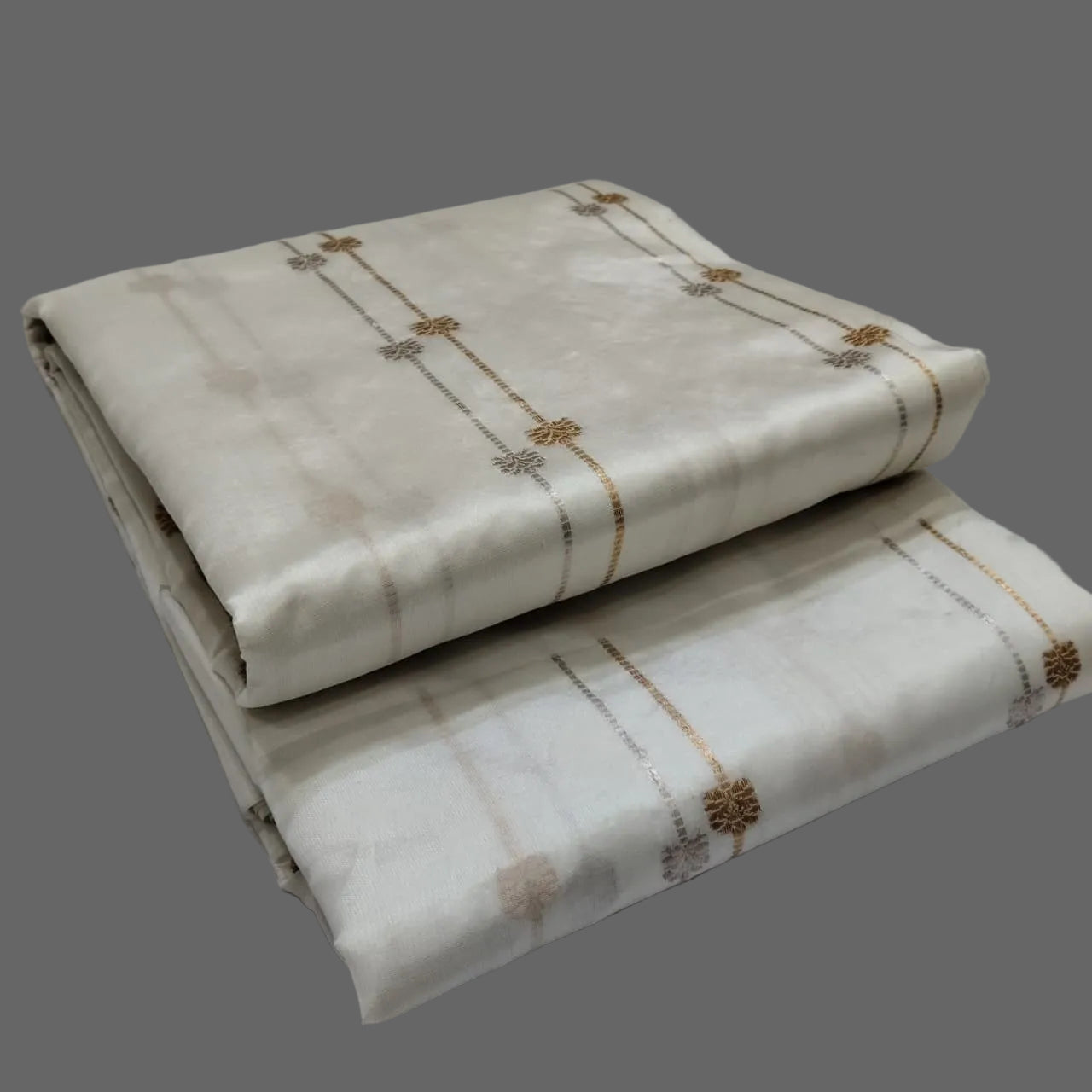 Two folded fabrics with subtle patterns on a white background