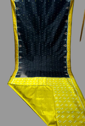 Black and yellow patterned fabric draped over a chair against a blue wall.