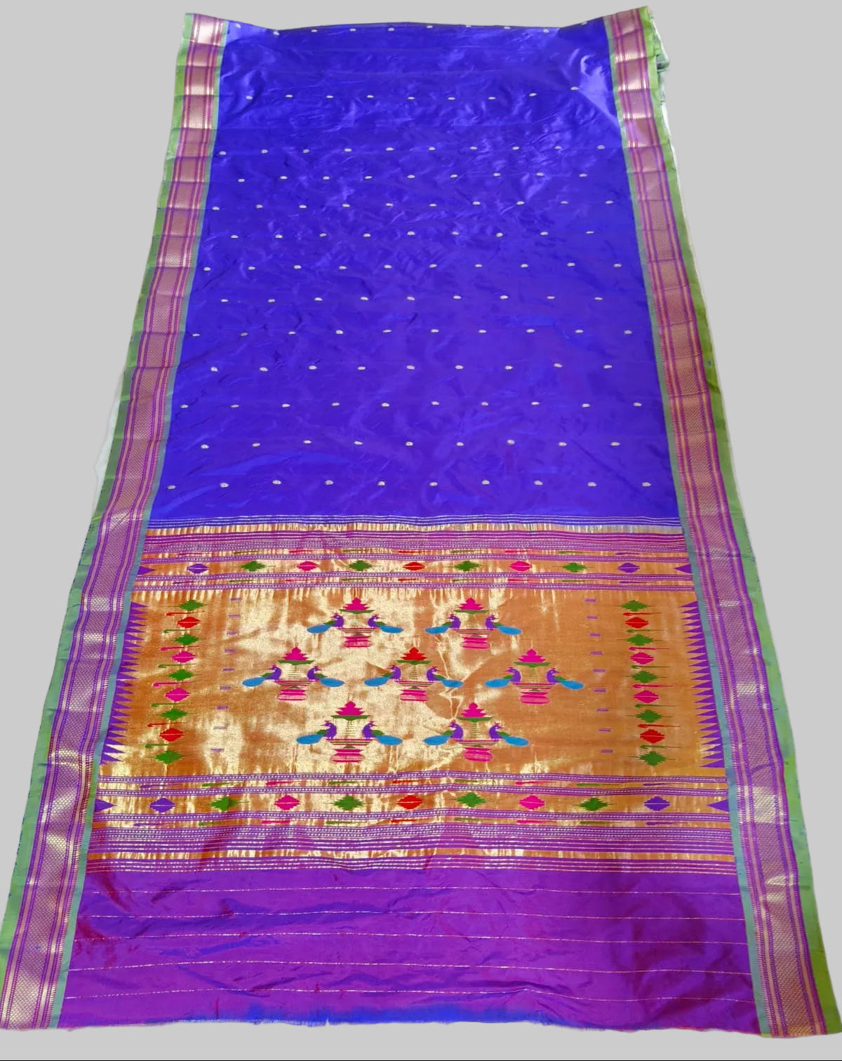 Blue and purple saree with intricate patterns on a white background